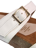 Primer plano de la sandalia Aura en color blanco, enfocando la textura suave de la plantilla ergonómica y los acabados de las correas.