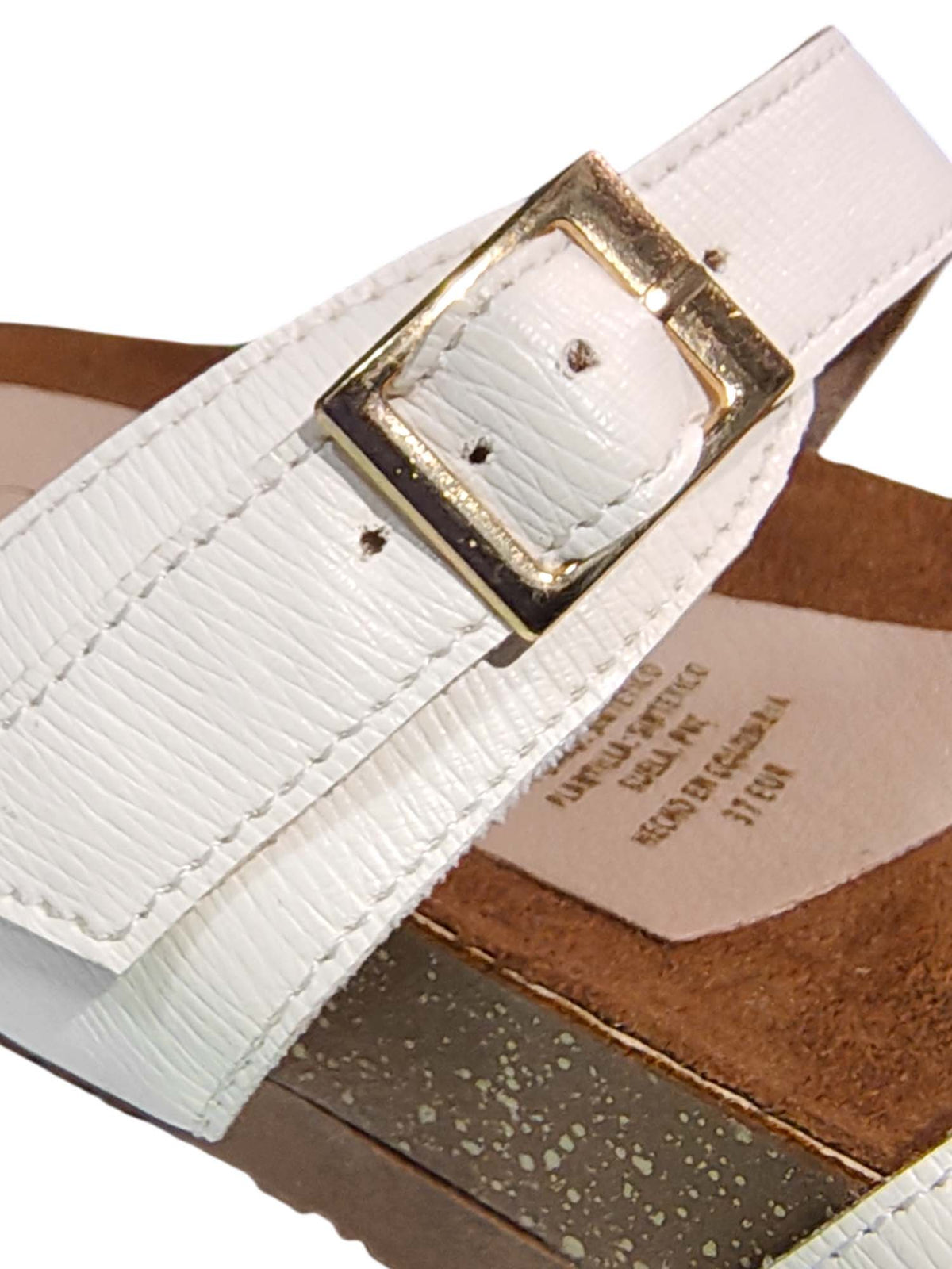 Primer plano de la sandalia Aura en color blanco, enfocando la textura suave de la plantilla ergonómica y los acabados de las correas.