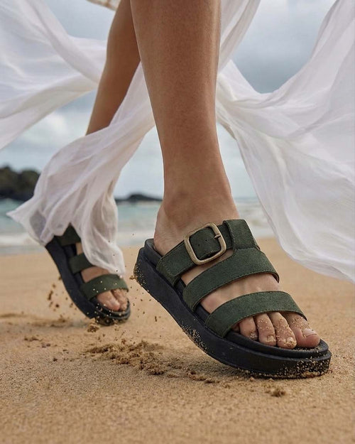Foto de estilo de vida de una modelo usando las sandalias Marea en color verde, complementando un outfit fresco, chic y relajado para el día a día.