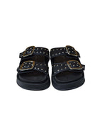 Toma frontal de las sandalias Zenith en color negro, detallando la distribución de las tiras sobre el empeine decoradas con taches metálicos.