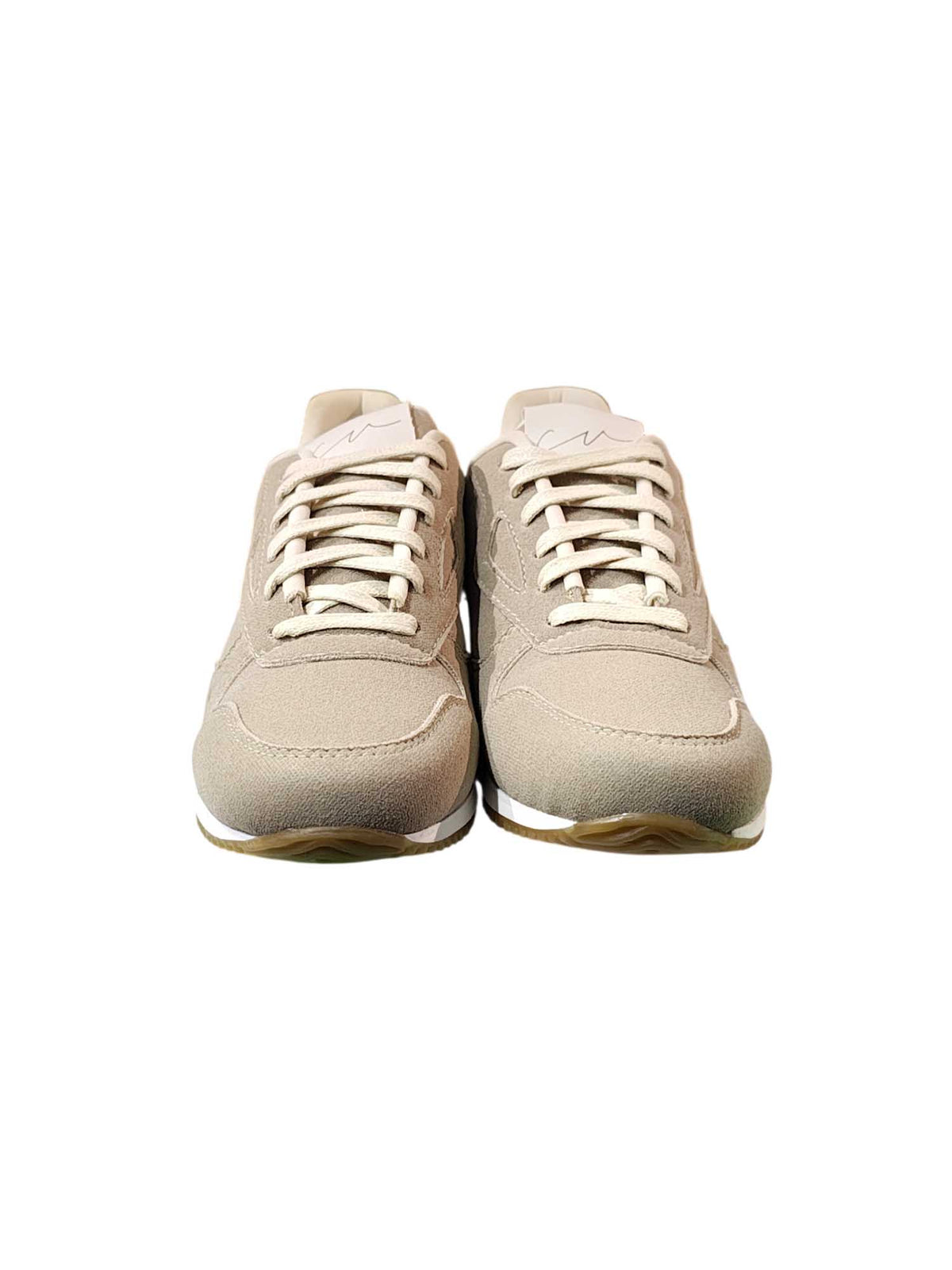 Toma de frente del calzado Egeo en color beige, detallando su diseño minimalista, cómodo y ultra combinable sobre el empeine.