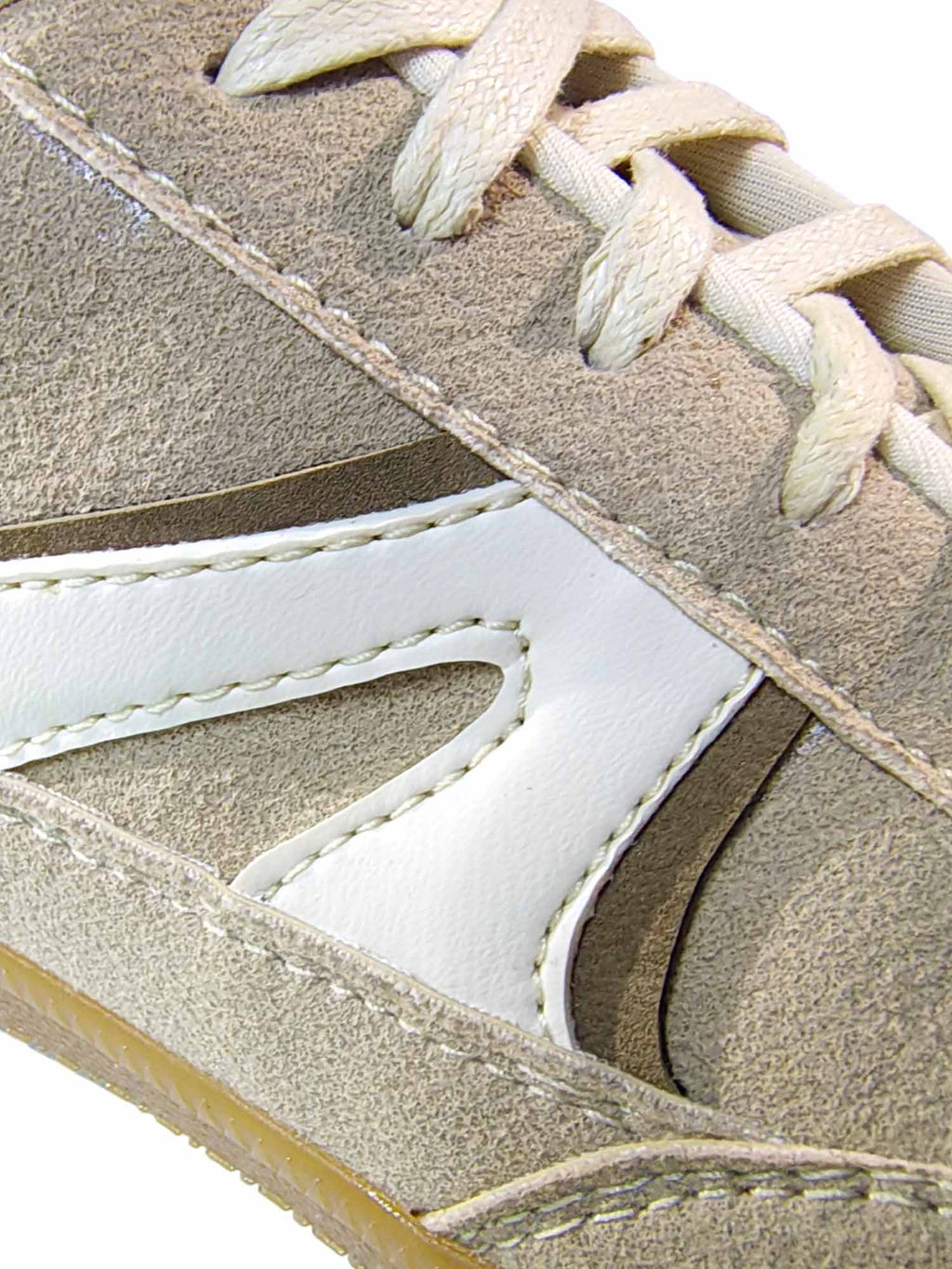 Primer plano del calzado Mistral en color beige, enfocando de cerca las diferentes texturas del material, la suavidad al tacto y los finos acabados de costura.
