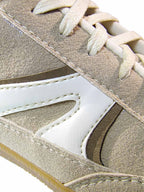 Primer plano del calzado Mistral en color beige, enfocando de cerca las diferentes texturas del material, la suavidad al tacto y los finos acabados de costura.