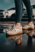 Foto de estilo de vida de una modelo usando el calzado plano Mistral en color beige, destacando un outfit urbano, fresco y en tendencia ideal para el ritmo diario.